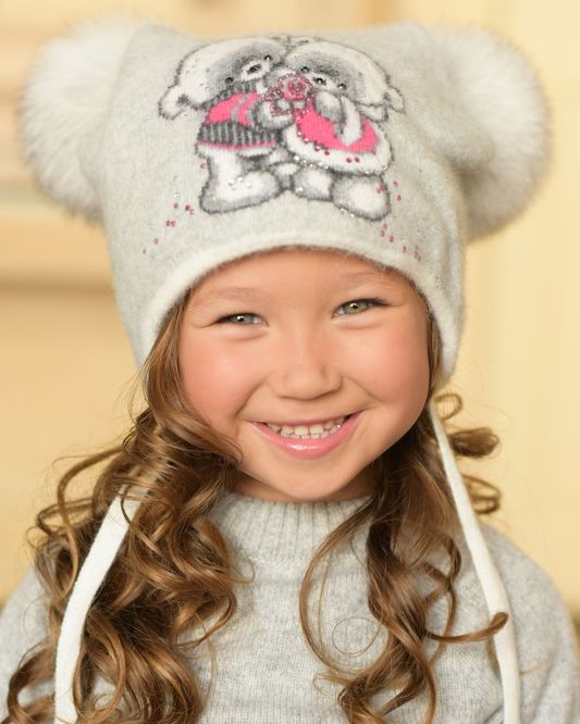 Фото — детская шапка с рисунком, завязками и двумя натуральными помпонами БАМБИНИ